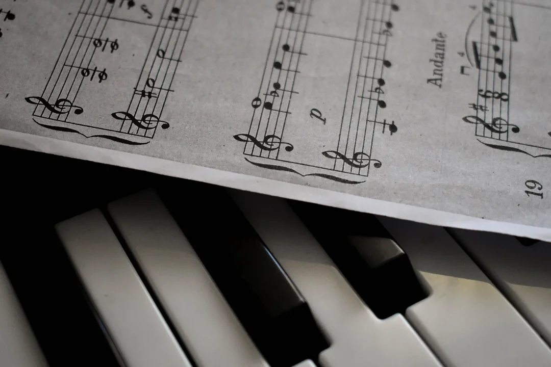 Teclado de piano junto a una partitura