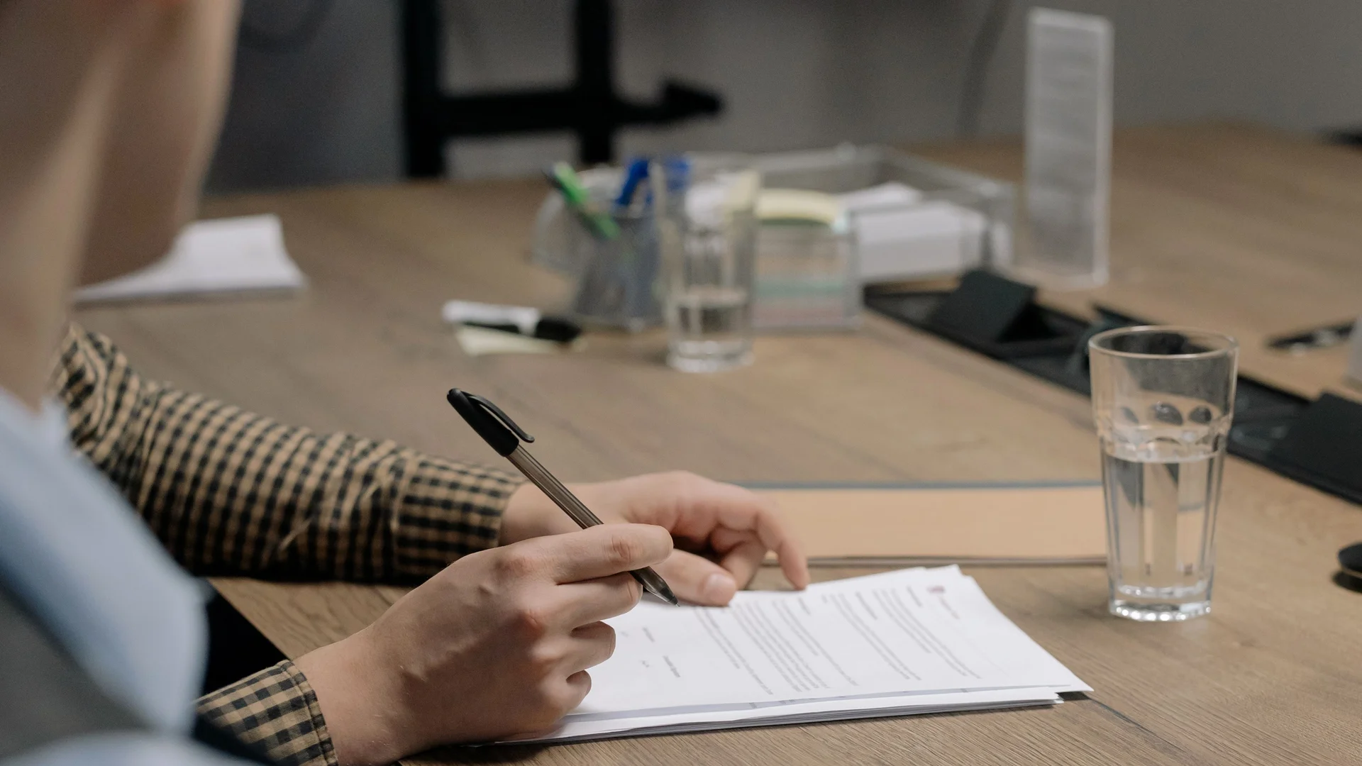 Firma de un contrato sobre una mesa de despacho