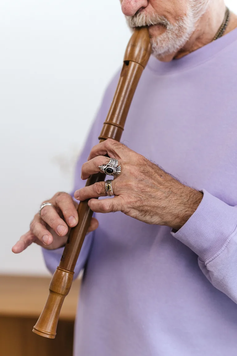 Persona mayor tocando una flauta de madera