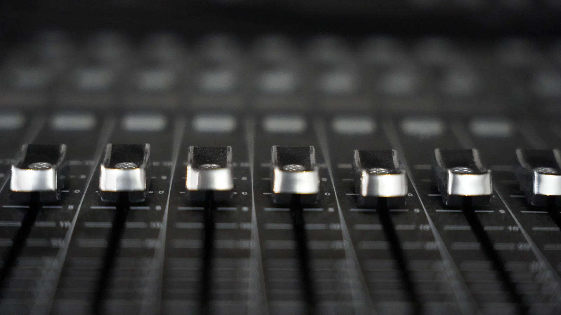 Faders de una mesa de mezclas en detalle