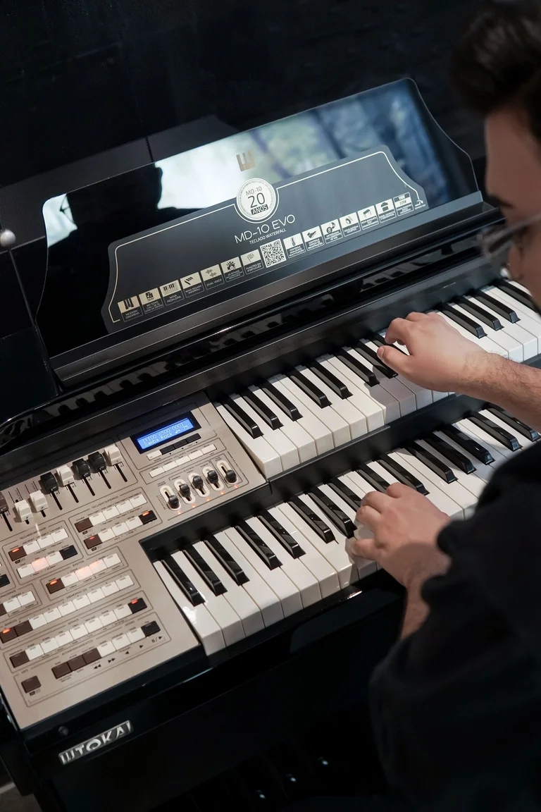 Organista tocando un órgano eléctrico de doble manual